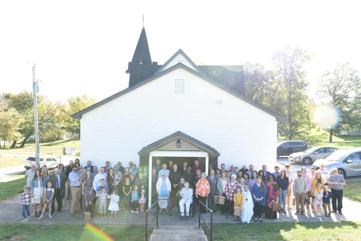 Bishop W. Shawn McKnight and Father Joseph Abah join members of St. Jude Thaddeus Parish in Mokane in a group photo outside their newly renovated church Oct. 22 after celebrating the Rededication Mass.